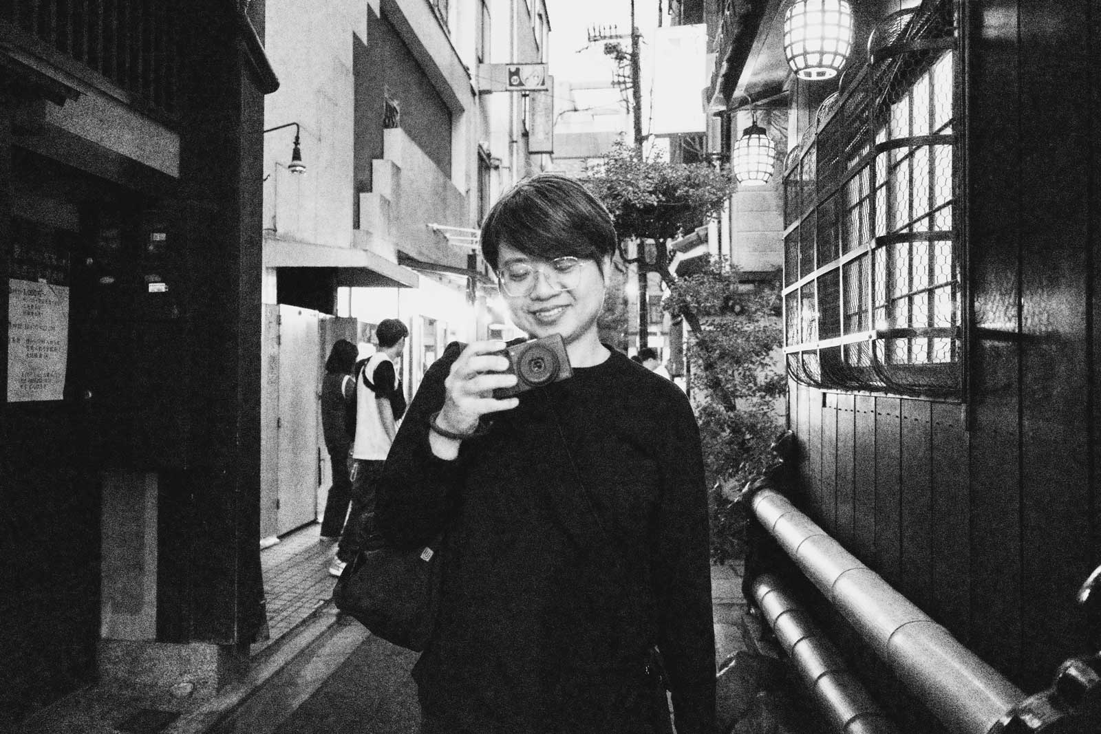 mookio 阿默拿著 Ricoh GR 相機在街頭散步拍攝的身影